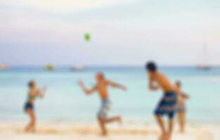 Blurred scene friends playing ball on beach photo