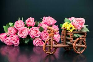 Wooden toy car with bouquet of pink roses photo