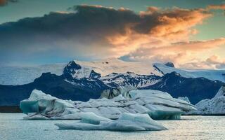 Scenery of Jokulsarlon glacier lagoon with blue iceberg melting and sunset sky on summer photo