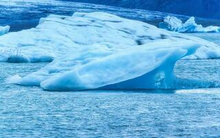 Natural blue iceberg floating and melting in Jokulsarlon glacier lagoon photo