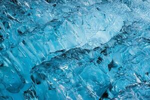 Abstract blue ice cracks from iceberg in glacier natural background photo