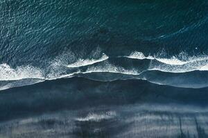 Moody atlantic ocean wave on black sand beach in summer at Iceland photo