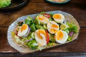 Stir fried mixed salad with boiled egg and sauce, Healthy food in ceramid plate photo