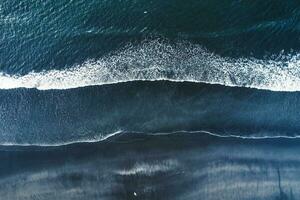 Moody atlantic ocean wave on black sand beach in summer at Iceland photo