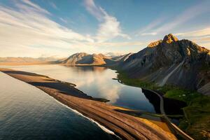 hermosa amanecer terminado volcánico montaña rango en rural escena por el Oceano de península a verano en Islandia foto