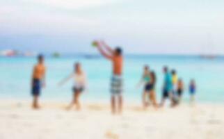 Blurred scene friends playing ball on beach photo