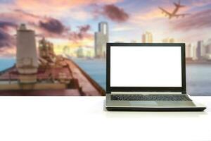 Laptop on white desk with blurred scene cargo shipping with plane export to city photo