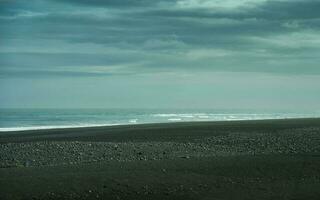 Moody of Atlantic sea with black sand beach in remote wilderness photo