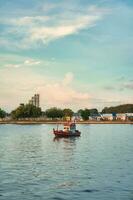 Wooden fishing trawler boat on tropical sea in the evening photo