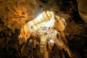 grande cavidad caliza cueva luz de sol brillar debajo tierra foto