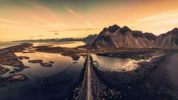 hermosa amanecer terminado vestrahorn montaña vikingo pueblo y la carretera entre negro arena playa en Stokksnes en verano a Islandia foto