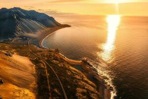 Beautiful sunrise over volcanic mountain range in rural scene by the ocean of peninsula at summer in Iceland photo