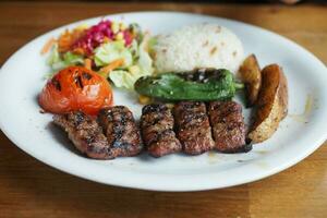 brocheta, tradicional turco carne comida con ensalada en un plato foto