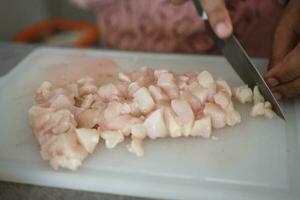 cutting breast chicken meat on a chopping board photo