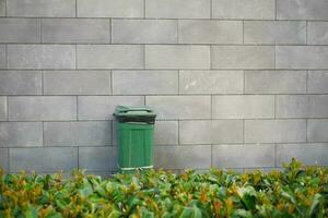 Bag with garbage and rubbish bin against gray color wall photo