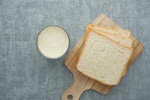 glass of milk and bread on table photo