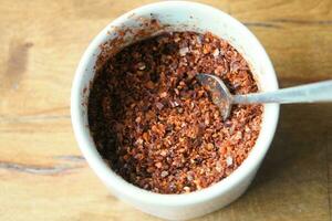 chili flakes in a bowl on table photo