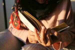 Muslim women's hand reading quran at night photo