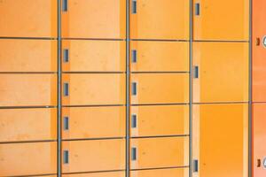 orange color storage box in public place. safe storage locker for shopping malls photo