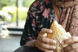 women eating club sandwich in a paper packet photo