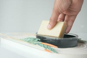 women hand pick a natural soap bar on table photo