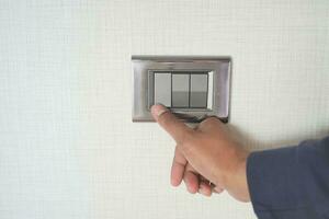 A finger turning on lighting switch with copy space photo