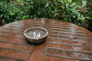 Close up burning cigarette in ashtray on table photo