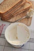 Slice of bread and cream cheese on white background. photo