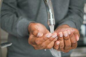 young man washing hands with soap warm water photo