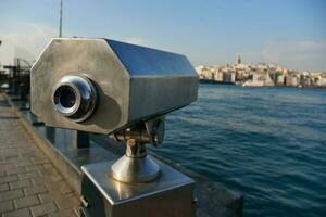 Coin-operated binoculars looking out over city , photo