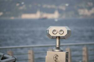 Coin-operated binoculars looking out over city , photo