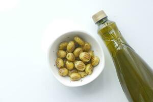 Turkish Grilled olives in a bowl and oil bottle on white photo