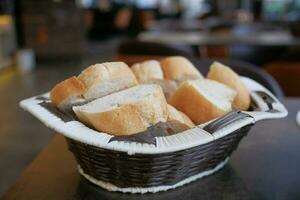 francés un pan baguettes en madera cesta en café mesa foto