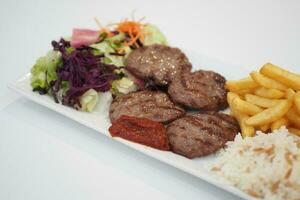 Kebab, traditional turkish meat food with salad on a plate photo