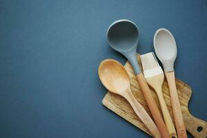 wooden cutlery forks and a chopping board on black color background photo