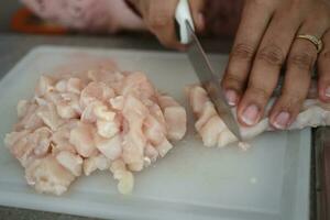 cutting chicken fillet at cooking classes. photo