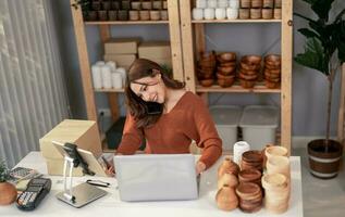 Vase brand owner processes online orders. Response to customer queries and concerns about products and shipment to increase long term loyalty and satisfaction. Routine work of e commerce entrepreneur photo