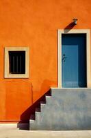 An orange wall with a door and steps, in the style of light emerald and indigo. AI generative photo