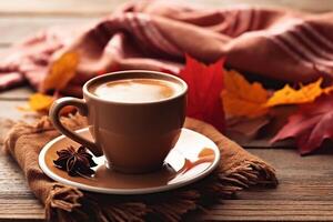 Autumn, fall leaves, hot cup of coffee and warm scarf on wooden table background. photo