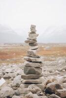 un minimalista inukshuk hecho de apilado piedras señalando el camino a través de el Alaska tundra. ai generativo foto