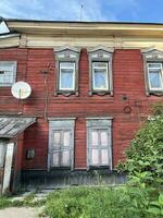 18 of July 2022 - Irkutsk, Russia. Dilapidated wooden house in a state of disrepair, still inhabited by people photo