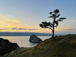 rock chamanka en olkhon isla a atardecer, lago Baikal, Rusia foto