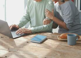 Embraced mature couple surfing the Internet on laptop at home photo