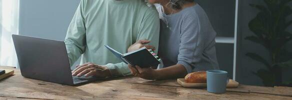 Embraced mature couple surfing the Internet on laptop at home photo