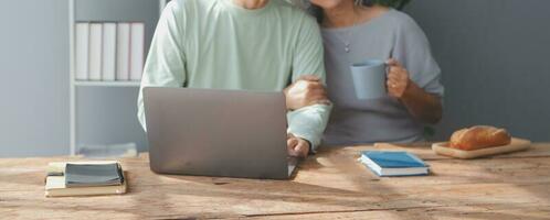 Embraced mature couple surfing the Internet on laptop at home photo