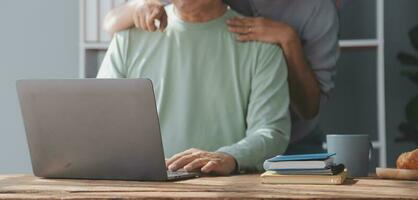 Happy mature couple using laptop at home photo