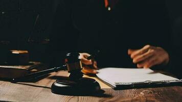 Justice and law concept.Male judge in a courtroom with the gavel, working with, computer and docking keyboard, eyeglasses, on table in morning light video
