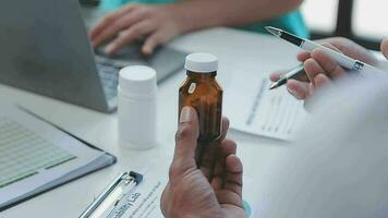 gruppo di assistenza sanitaria lavoratori e uomo d'affari utilizzando il computer portatile mentre avendo un' incontro nel il ufficio. messa a fuoco è su giovane medico. video