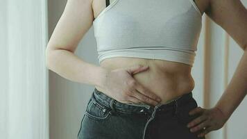 mujer cuerpo grasa barriga. obeso mujer manos participación excesivo barriguita gordo. cambio dieta estilo de vida concepto a forma arriba sano estómago músculo. estudio anónimo Disparo foto de cuerpo partes. video