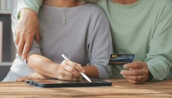 Close up mature man holding plastic credit card, senior couple family paying online, using laptop, satisfied older customers making secure internet payment, shopping, browsing banking service photo